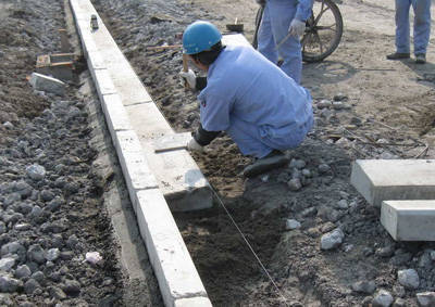 牙石安裝完畢，工人正在安裝平石